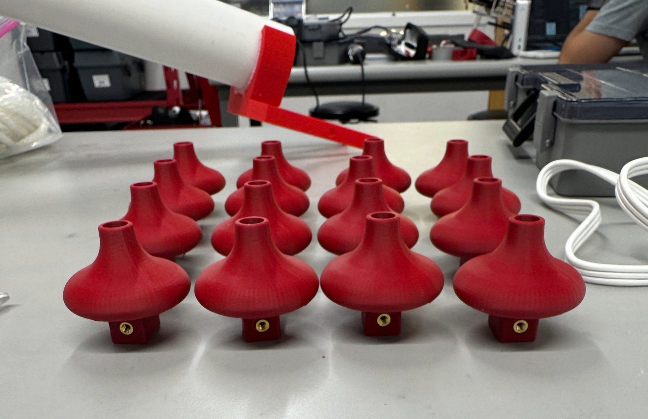 Array of red 3D printed pump impellers